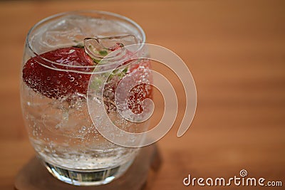 Healthy drink of sparkling water in a glass with fresh strawberries Stock Photo