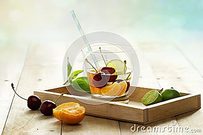 Healthy detox water, glass of cherry, orange and lime on wooden tray Stock Photo