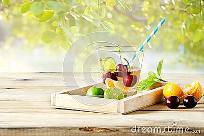 Healthy detox water, glass of cherry, orange and lime on wooden tray Stock Photo