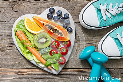 Healthy diet and sport concept with dumbbells trainers and food Stock Photo