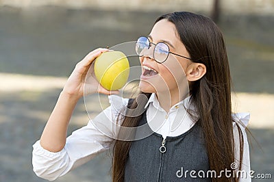 Healthy dose of vitamin C. Happy kid eat apple outdoors. School snack. Vitamin nutrition. Health education. Eating right Stock Photo