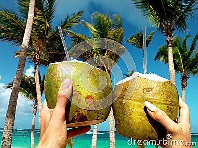 Healthy drink on a Caribbean beach. Pineapple and coconut handheld on the beach Stock Photo
