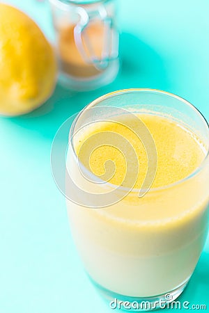 Healthy Drink Made from Turmeric Roots, Exotic Spices with Coconut Milk, Honey and Ghee on Blue Background Stock Photo