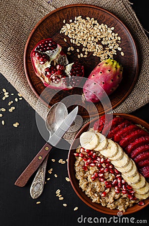 Healthy eating concept. Balanced breakfast with oats porridge,banana, pomegranate seeds and opuntia cactus fruit. Flat lay, top Stock Photo
