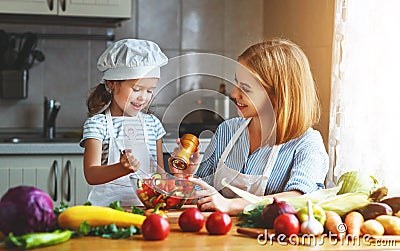 Healthy eating. family mother and child girl preparing vegetarian vegetable salad at home in kitchen Stock Photo