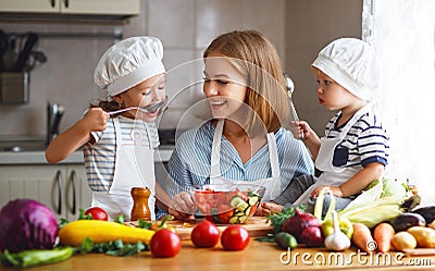 Healthy eating. Happy family mother and children prepares vegetable salad Stock Photo