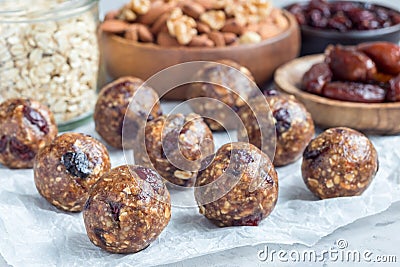 Healthy energy balls with cranberries, nuts, dates and rolled oats on parchment, horizontal Stock Photo