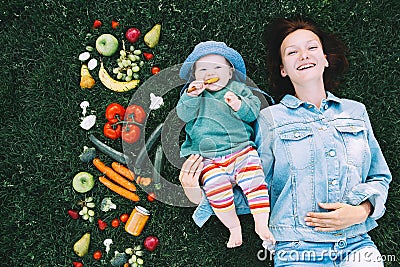 Healthy family nutrition. Mother and baby with fruits and vegetables. Stock Photo