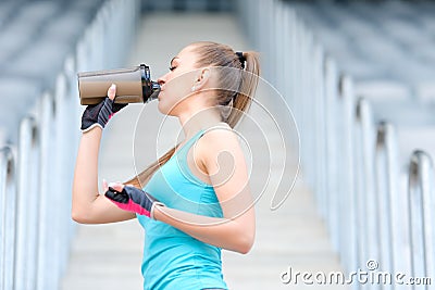 Healthy fitness girl drinking protein shake. Woman drinking sports nutrition beverage while working out Stock Photo