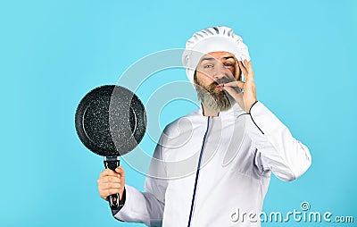 Healthy food. Bearded chef preparing breakfast. Frying without oil. Professional kitchenware. Teflon might be toxic Stock Photo