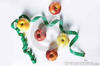 Healthy food concept - fresh fruits and measuring tape, apples and weight loss on a white background. Stock Photo