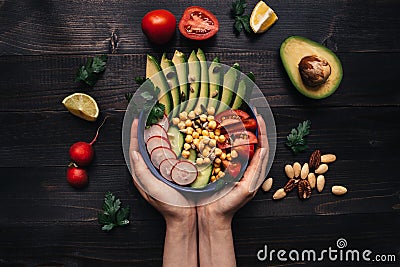 Healthy food concept. Hands holding healthy salad with chickpea and vegetables. Vegan food. Vegetarian diet Stock Photo