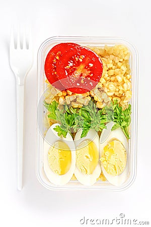 Healthy food concept: lunch box filled with bulgur, vegetables, boiled egg and parsley, top view Stock Photo