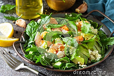 Dieting dinner close-up. Couscous salad with arugula, avocado and grilled shrimps Stock Photo