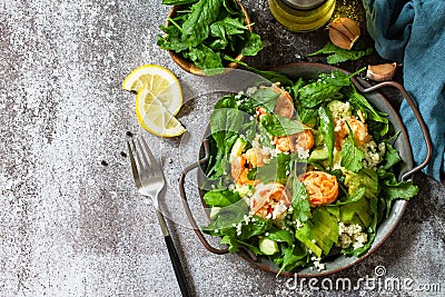 Healthy food. Dieting dinner. Couscous salad with arugula, avocado and grilled shrimps. Top view flat lay background. Stock Photo