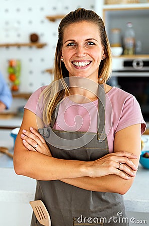 Healthy food at home. Happy woman is preparing organic bio meal in the kitchen. Stock Photo