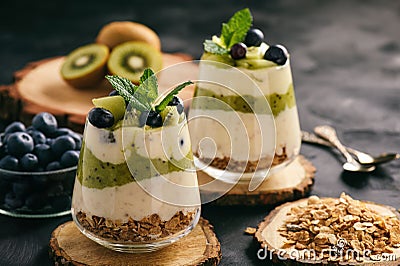 Healthy food -layered dessert with yogurt, muesli, kiwi and blueberry. Stock Photo