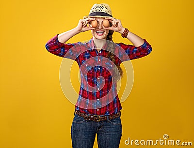 Happy woman grower holding eggs in front of face like eyes Stock Photo