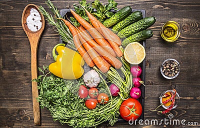 Healthy foods, cooking and vegetarian concept fresh carrots cherry tomatoes, garlic, cucumber, lemon, pepper, radish, wooden spoon Stock Photo