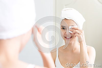Healthy fresh girl removing makeup from her face with cotton pad Stock Photo