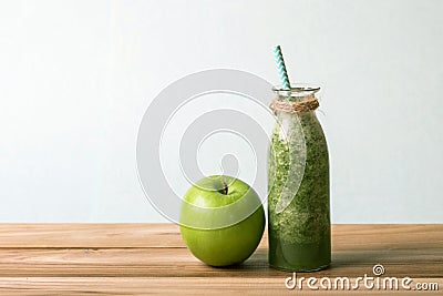 Healthy fresh green smoothie juice in the glass bottle on wooden table for healthy detox and diet habits concept Stock Photo
