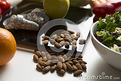 Healthy fruit,vegetables and nuts, scales and measuring tape. Weight loss and right nutrition concept Stock Photo