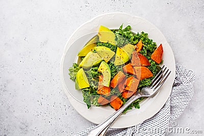 Healthy green kale salad with avocado and baked sweet potatoes, copy space. Plant based diet concept, detox food Stock Photo