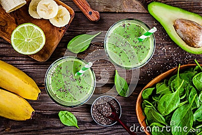 Healthy green smoothie with banana, lime, spinach, avocado and chia seeds in glass jars Stock Photo