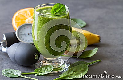 Healthy green smoothie with spinach and pressure gauge, concept of healthy diet for hypertension Stock Photo