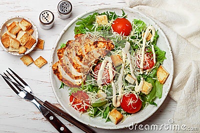 Healthy Grilled Chicken Caesar Salad with iceberg or lettuce, Cheese Parmesan, cherry tomatoes, bread Croutons and gourmet sauce Stock Photo