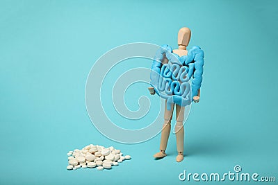 Healthy intestines in hands of human figure. Digestive problems, colic, dysbacteriosis. Digestive medicine, probiotic pills Stock Photo