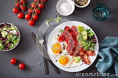 Healthy keto diet breakfast: egg, tomatoes, salad leaves and bacon Stock Photo