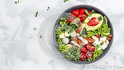 Healthy keto, ketogenic lunch menu with grilled chicken meat, avocado, feta cheese, quail eggs, strawberries, nuts and lettuce. Stock Photo
