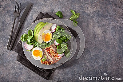 Healthy keto paleo diet breakfast: boiled egg, avocado, halloumi cheese, salad leaves Stock Photo