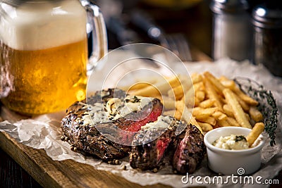 Healthy lean grilled medium-rare steak with french fries, beer Stock Photo