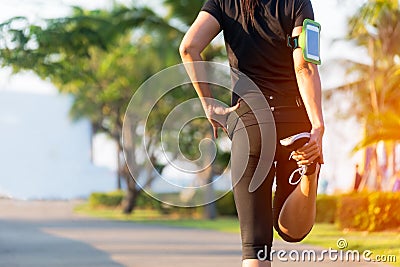 Healthy Life. Asian fitness woman runner stretching legs before run outdoor workout in the park. Stock Photo