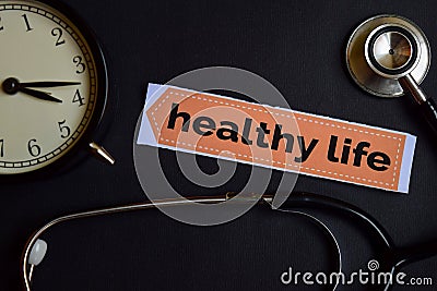 Healthy Life on the print paper with Healthcare Concept Inspiration. alarm clock, Black stethoscope. Stock Photo