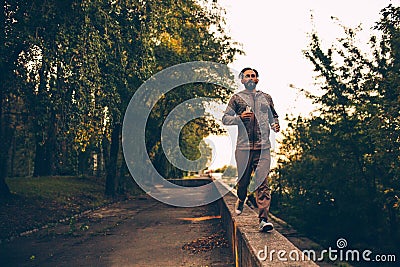 Healthy lifestyle adult sportive man running in the city park Stock Photo