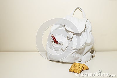 White backpack, pencils and oats biscuits Stock Photo