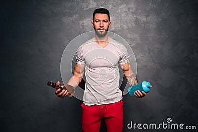 Lifestyle concept - portrait of shirtless muscular caucasian man holding a bottle of alcohol and a bottle of water Stock Photo