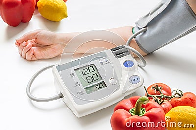 Healthy lifestyle concept. Woman is measuring blood pressure with monitor. Stock Photo