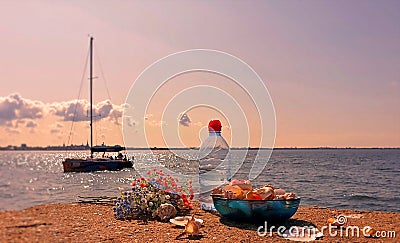 Healthy lifestyle Ecology Wonderful world Wild flowers fresh water in clean Baltic Sea seashell on rock i blue glass cup and bott Stock Photo