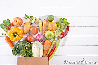 Healthy lifestyle and food concept. Top view paper bag of different fresh vegetables on white wooden background. Flat lay Stock Photo