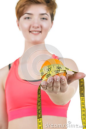 Healthy lifestyle, healthy eating. A young girl holds an orange and a measuring tape, on a white background. Horizontal frame Stock Photo