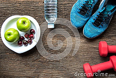 Healthy lifestyle sport equipment fitness, sneakers, green apple, fresh water and healthy food on old wood background. Stock Photo