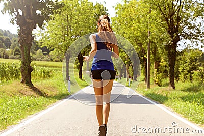 Healthy lifestyle sports woman running on asphalt driveway. Fitness woman running on asphalt road. Stock Photo