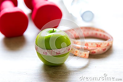 Healthy lifestyle for women diet with sport equipment, sneakers, measuring tape, fruit healthy green apples and bottle of water on Stock Photo