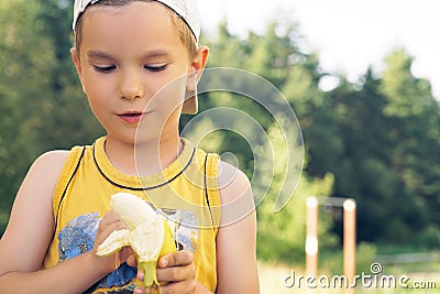 Healthy little boy eating banana. Happy kid enjoy eating fresh fruit. Stock Photo