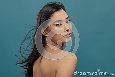 Well-groomed asian girl looking over shoulder to camera. Stock Photo