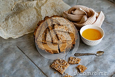 Healthy and nutritious diet bread with sesame and sunflower seeds on a thin crunchy malt base. Near natural bee honey and a wooden Stock Photo